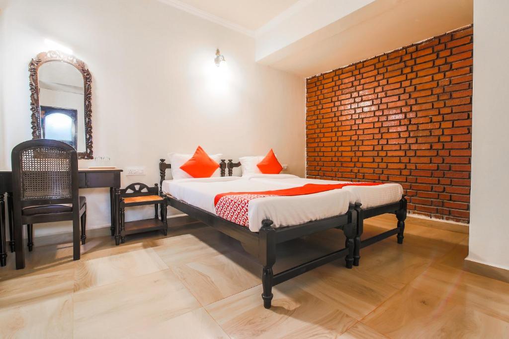 a bedroom with a bed and a mirror and a sink at OYO La Petite Near Dabolim Airport in Chicolna