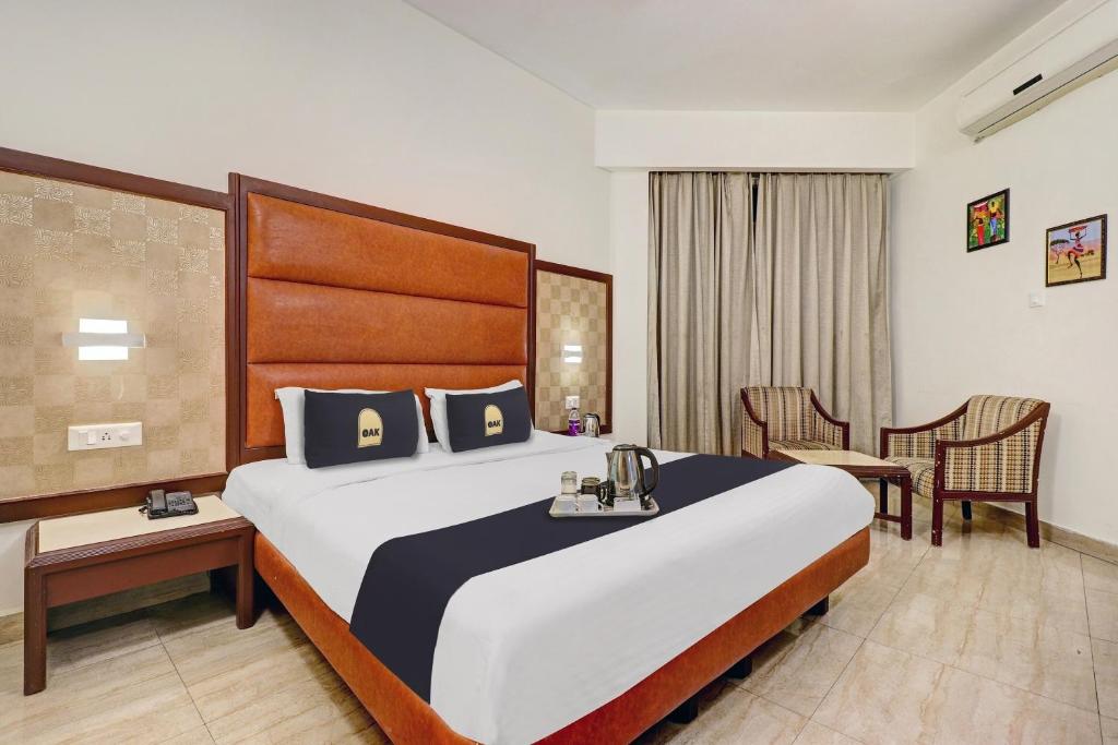 a hotel room with a large bed and a table at Townhouse Hw Residency in Dehradun