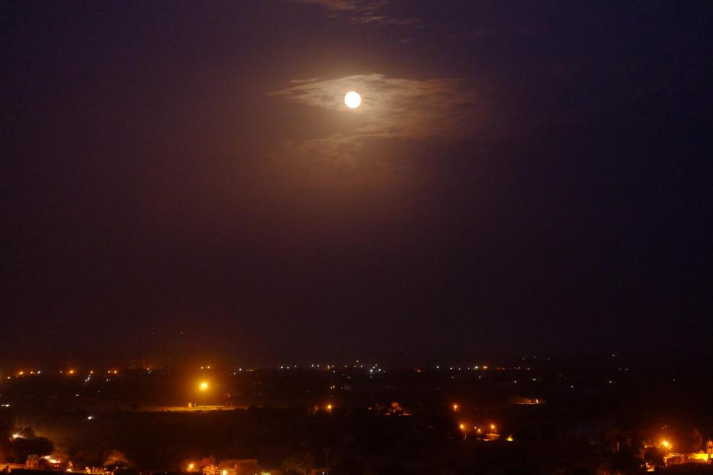 a moon in the sky over a city at night at Hotel Garh Jaisal Haveli in Jaisalmer