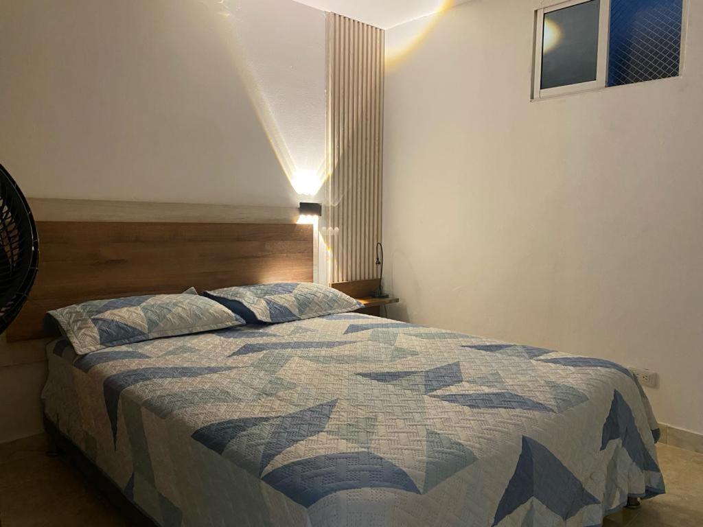 a bedroom with a bed with a quilt on it at Apartamentos en el Norte de cali in Cali