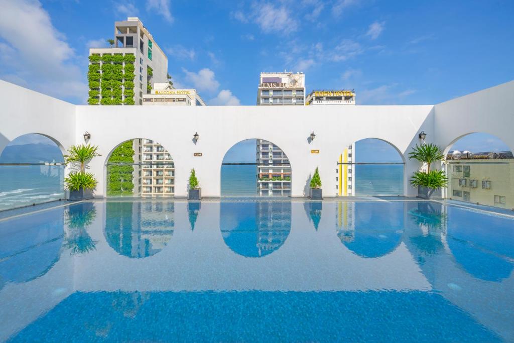 ein Pool mit Gebäuden im Hintergrund in der Unterkunft Golden Lotus Hotel Da Nang in Đà Nẵng