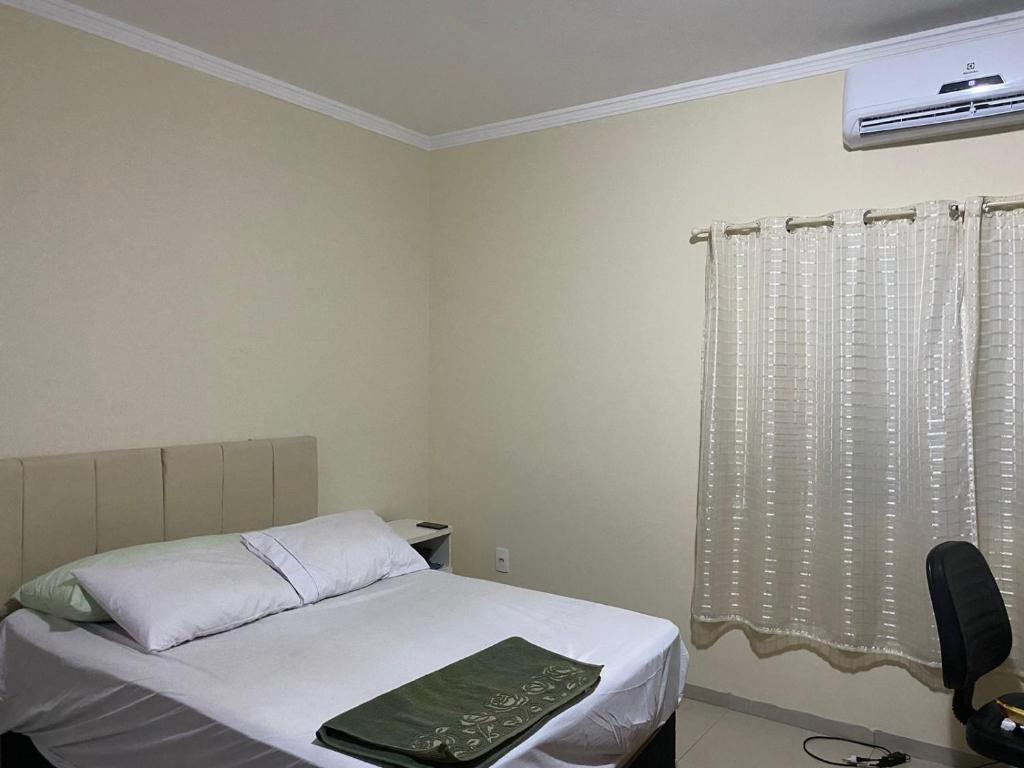 - une petite chambre avec un lit et une fenêtre dans l'établissement Lar Feliz, à Ibitinga
