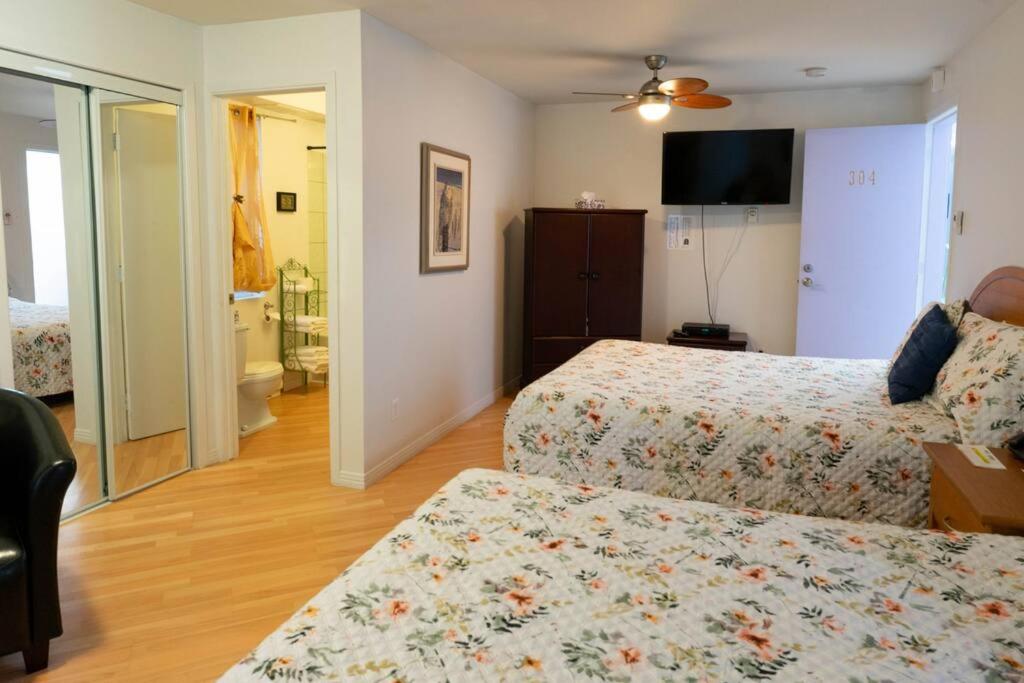 1 dormitorio con 2 camas y TV. en 304 Chambre Familiale Spacieuse, en Trois-Rivières