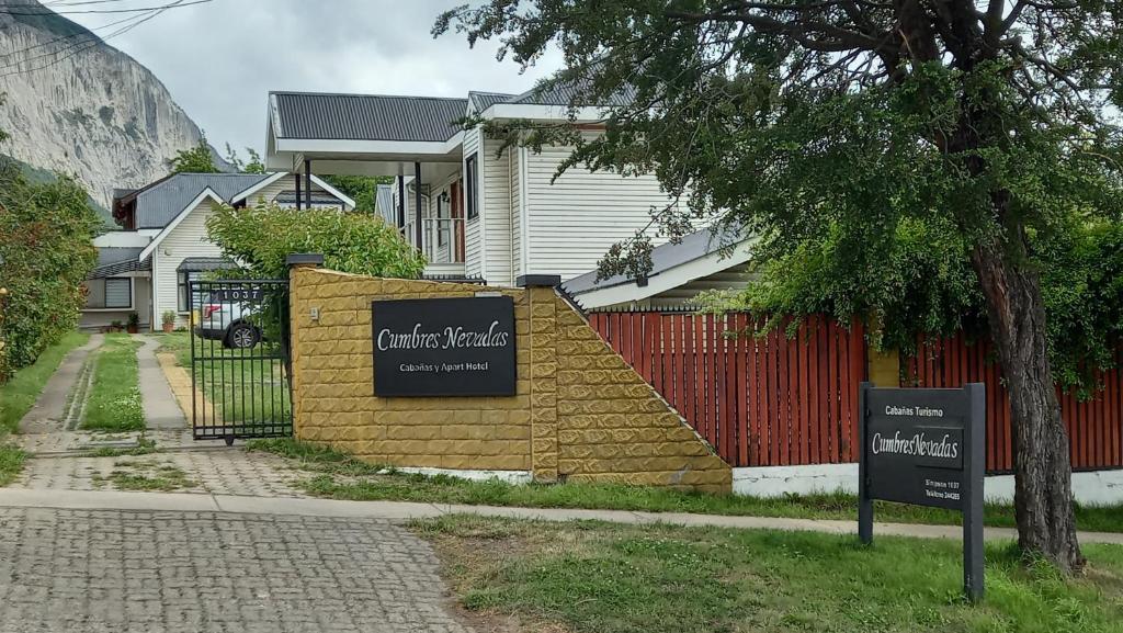 a house with two signs in front of it at Cumbres Nevadas in Coihaique