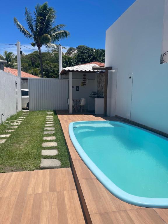 a swimming pool in the backyard of a house at Casa de praia Jauá in Camaçari