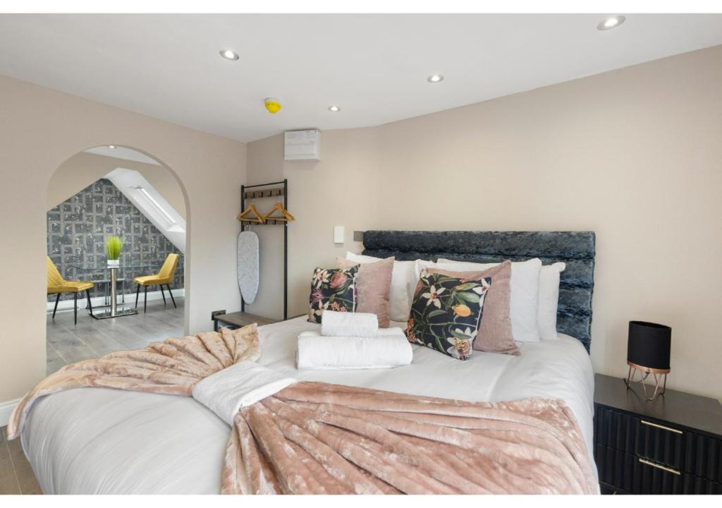 sypialnia z dużym białym łóżkiem z poduszkami w obiekcie Brand New Spacious & Chic Studio -Central Location w Londynie