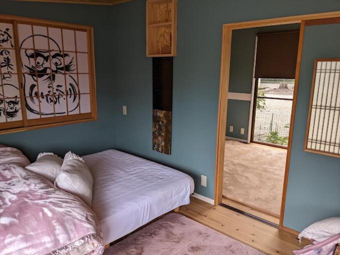 1 dormitorio con 1 cama y puerta a un patio en 民泊 福来, en Nasushiobara