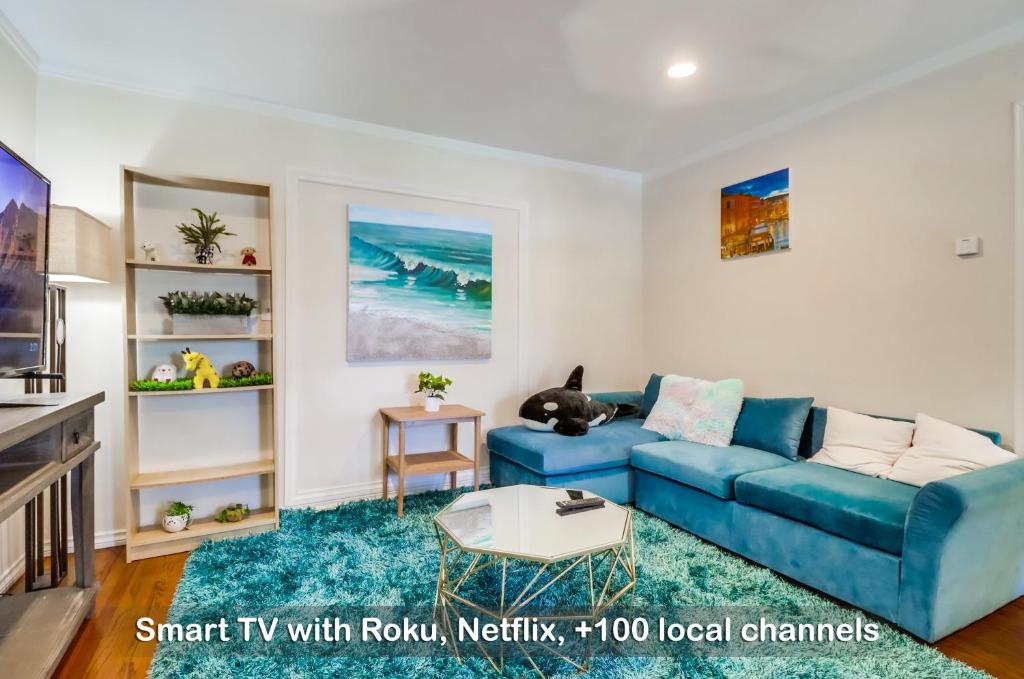 a living room with a blue couch and a table at Entire Private 3-Bedroom Home with Baby Crib, Wi-Fi & Laundry in San Diego