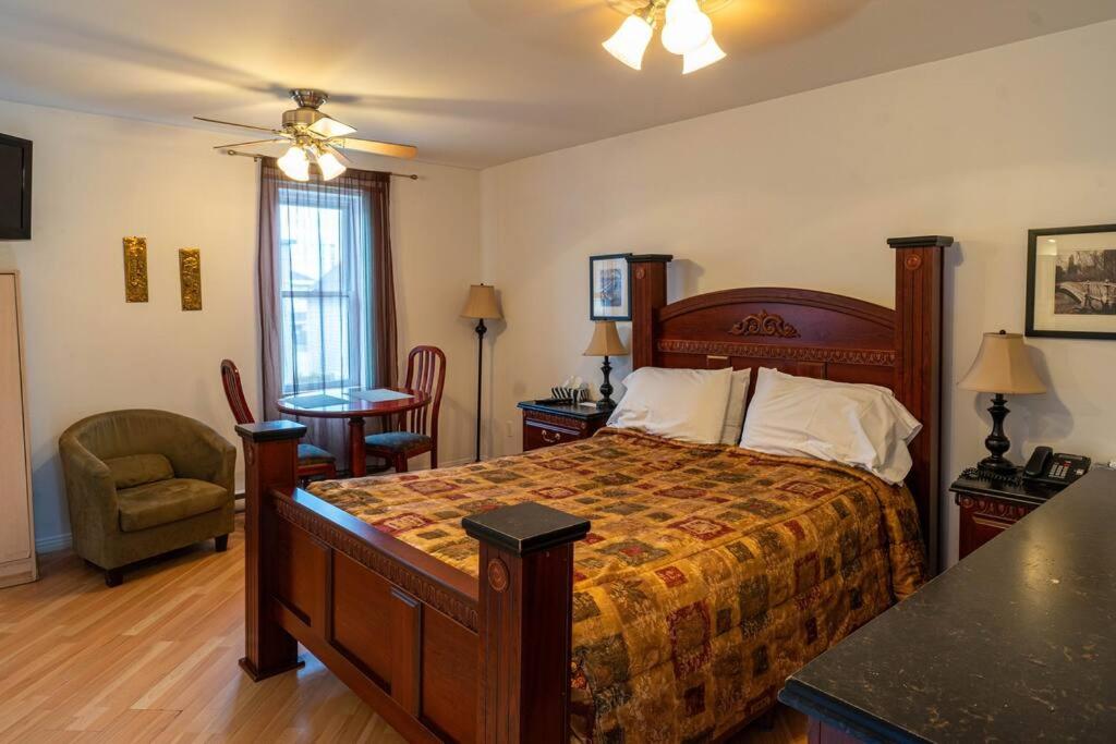 um quarto com uma cama, uma mesa e uma cadeira em 308 Charme Historique em Trois-Rivières