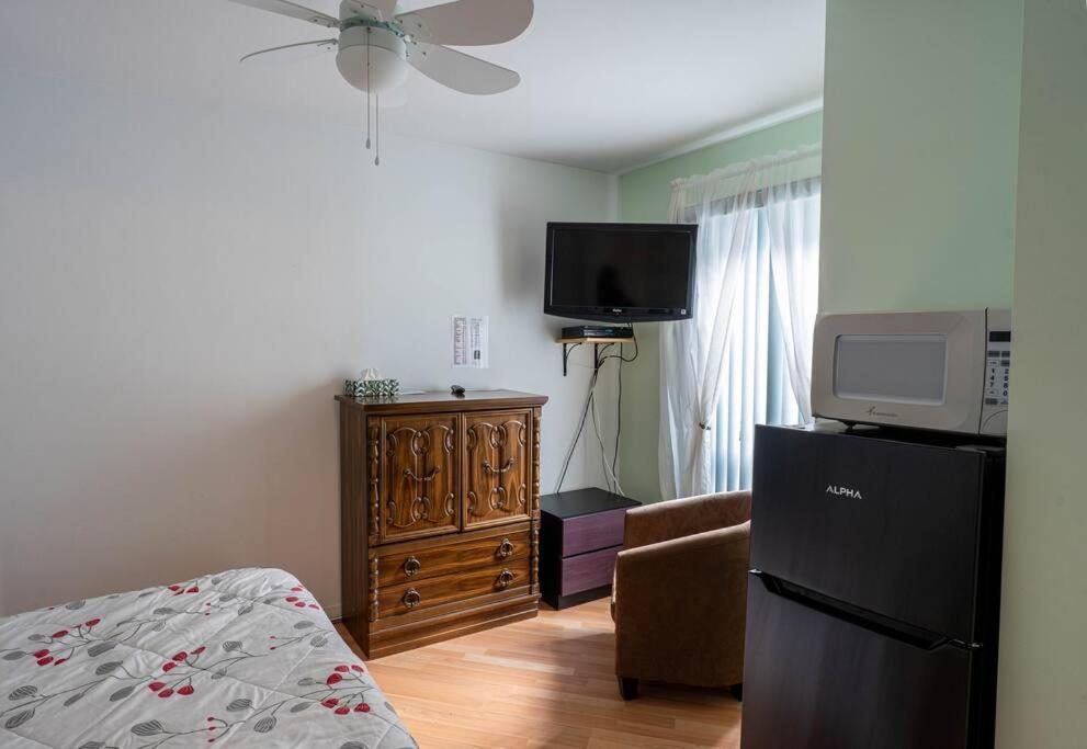 una sala de estar con cama y TV y una habitación en 311 Chambre Pratique et Confortable, en Trois-Rivières