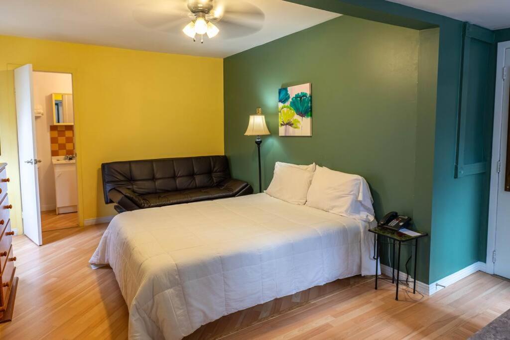 a bedroom with a bed and a couch at 310 Intimité au Cœur de l'Histoire in Trois-Rivières