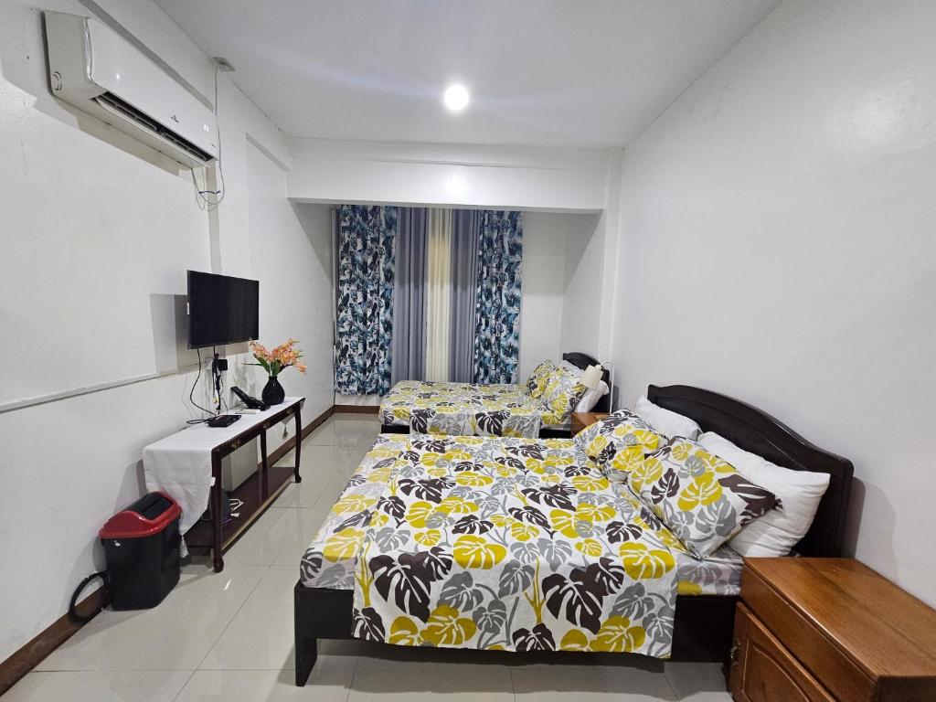 a bedroom with a bed and a television in it at 3MC Guest House in Butuan