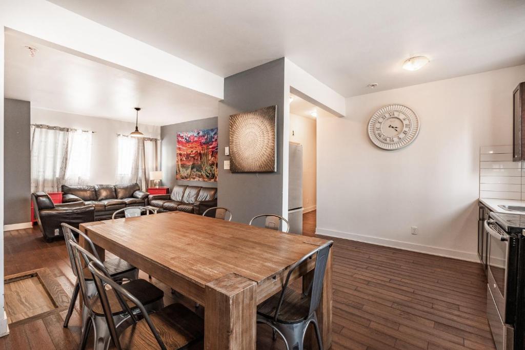 een keuken en een woonkamer met een houten tafel en stoelen bij Appartement 3 chambres - 2234 in Montreal