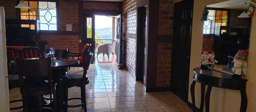 a dining room with a table and chairs and a hallway at Apartamento Concepción de Ataco, Los Tablones in Ahuachapán