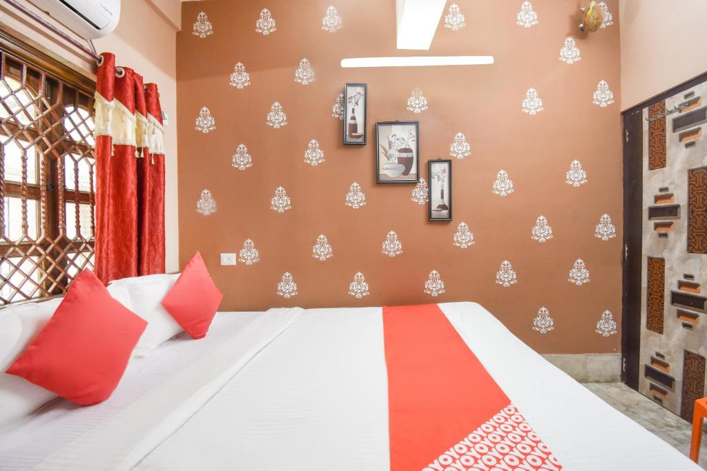 1 dormitorio con 1 cama con almohadas rojas y blancas en Fantasy Stay Near City Centre Salt Lake en Pātipukur
