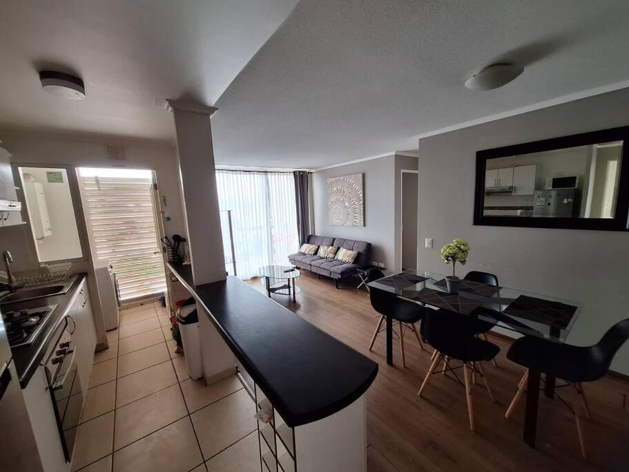 a kitchen and living room with a table and chairs at Excelente depto equipado completo, a pasos del mar in La Serena