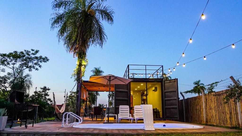 a tiny house with a palm tree and a patio at Container Lodge SB in San Bernardino