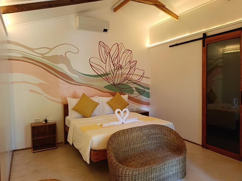 a bedroom with a bed with a flower mural on the wall at Kawai Duli Bungalows 1 in Duli