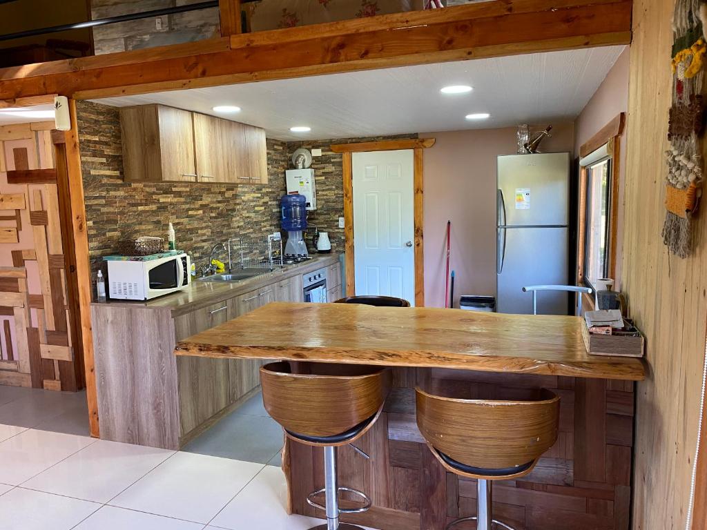 eine Küche mit einer Holztheke und einem Kühlschrank in der Unterkunft Cabaña El Polux, ruta x-671 in Coihaique
