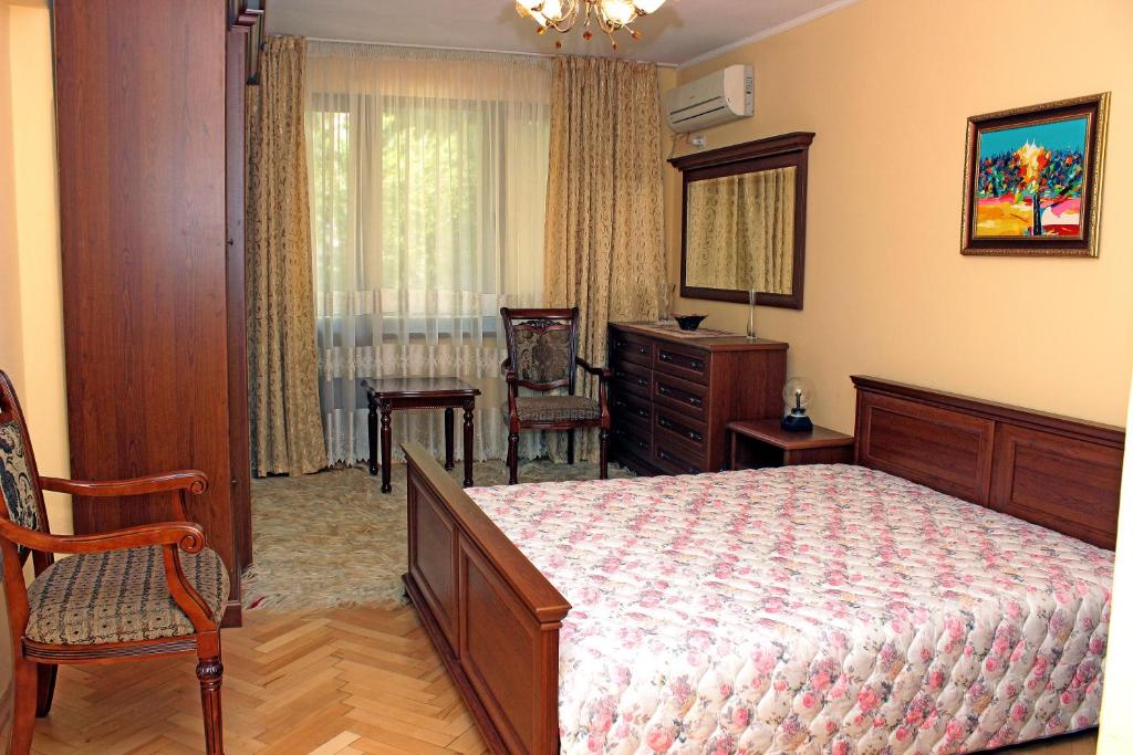 a bedroom with a bed and a chair and a dresser at Apartment downtown in Pazardzhik