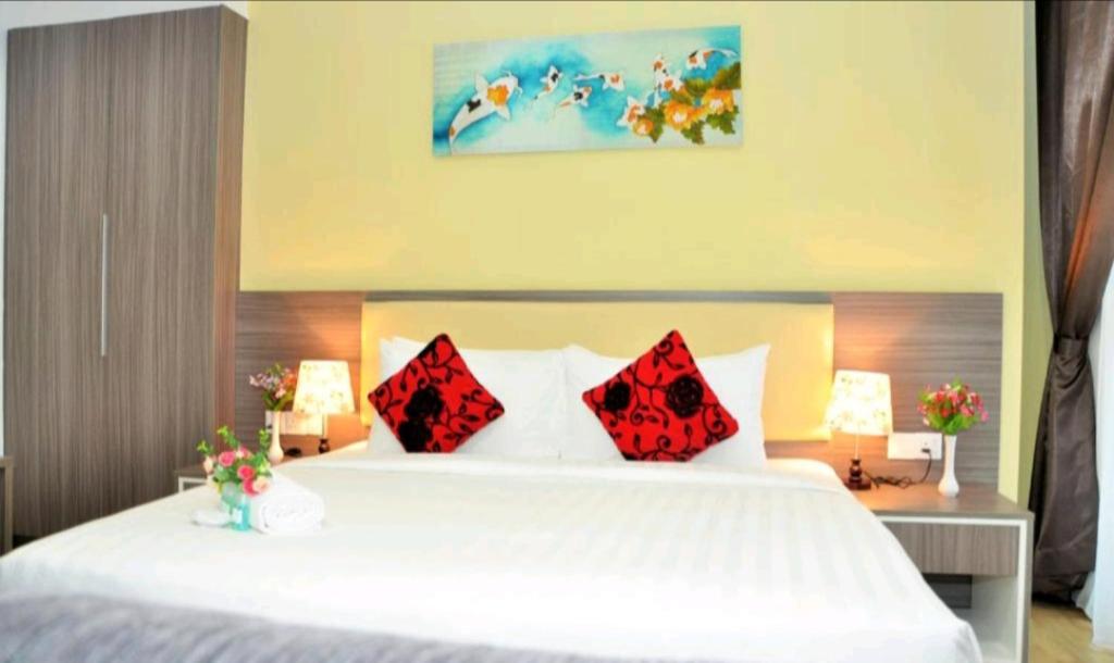 a bedroom with a large white bed with red pillows at Metra 308 Easy Suite in Ayer Keroh