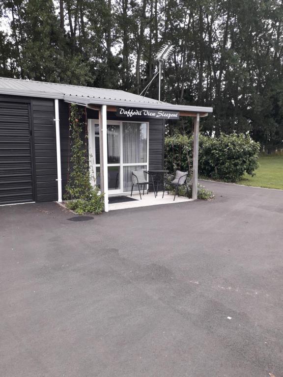 a garage with a table and a bench in it at Rural Gordonton Sleepout in Hamilton