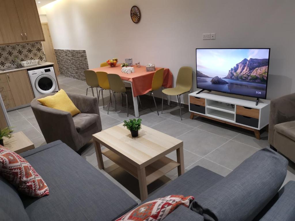 sala de estar con sofá y mesa con TV en PERSEUS 3 BEDROOM Apartment 102 en Lárnaca