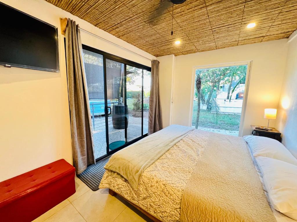 1 dormitorio con cama grande y ventana grande en Nirvana Beach Home, en Paraíso