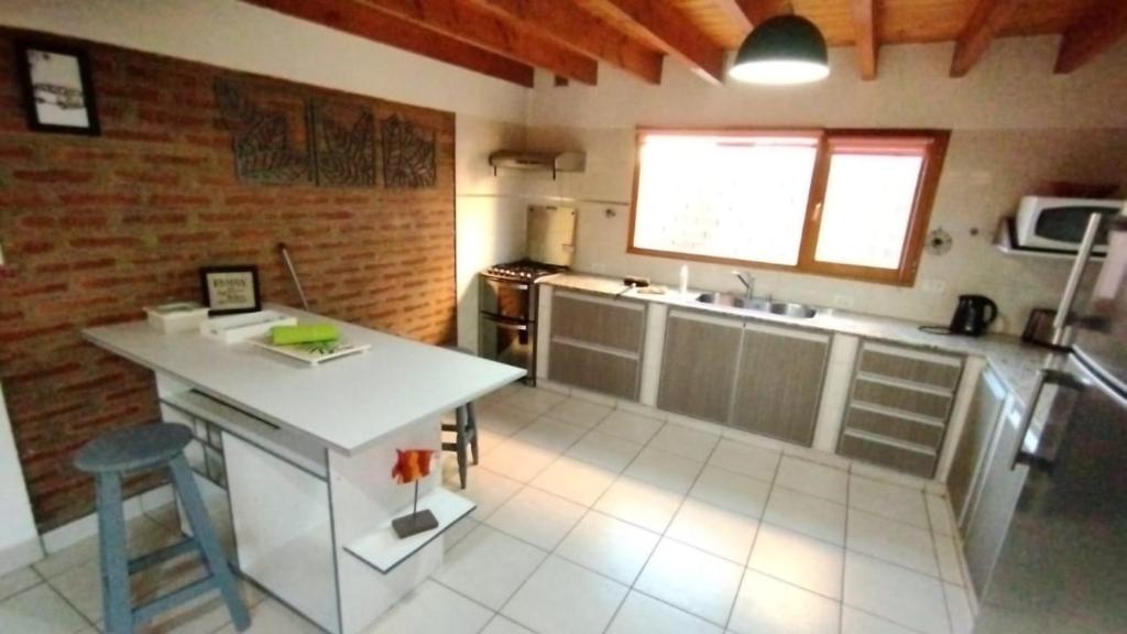 uma cozinha com um balcão e uma mesa em Esquel house em Esquel