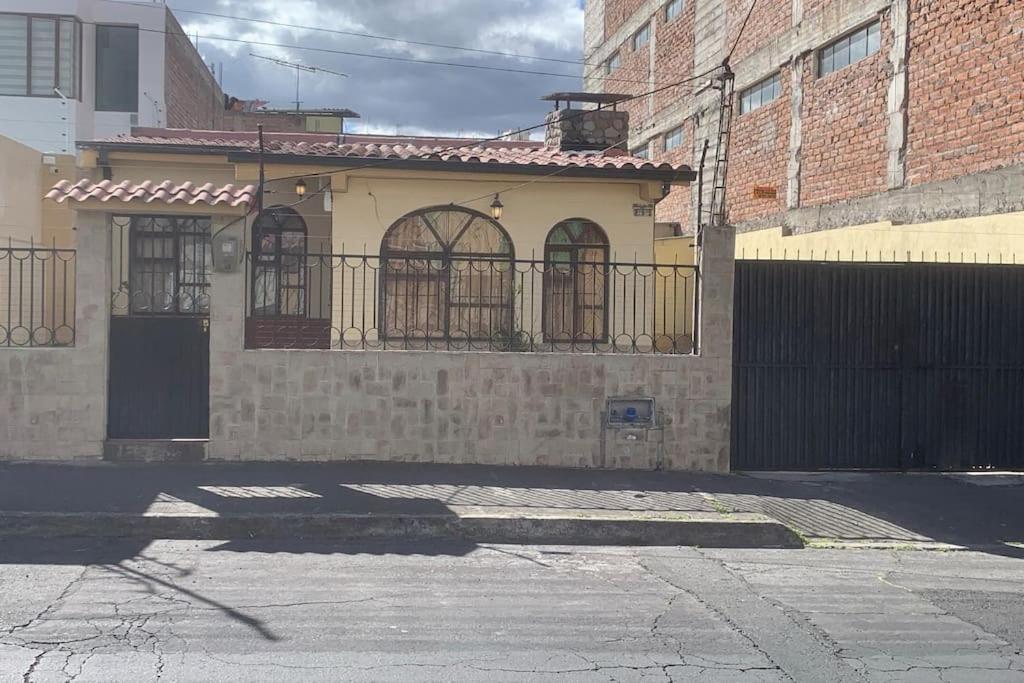 una pequeña casa con una puerta en una calle en Villa Paquita - Arco de Bellavista, en Riobamba