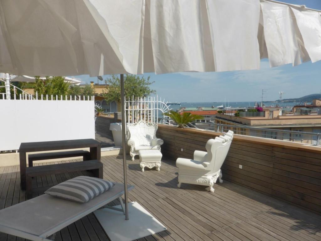 a patio with chairs and an umbrella on a roof at Casa Palmira in La Spezia