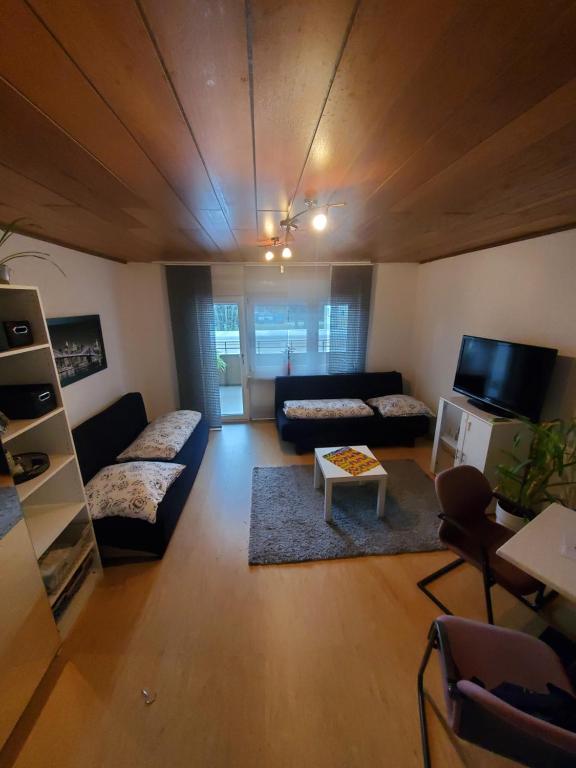 - un salon avec un canapé et une télévision dans l'établissement Einzimmerwohnungmit großem Balkon, à Mietersheim