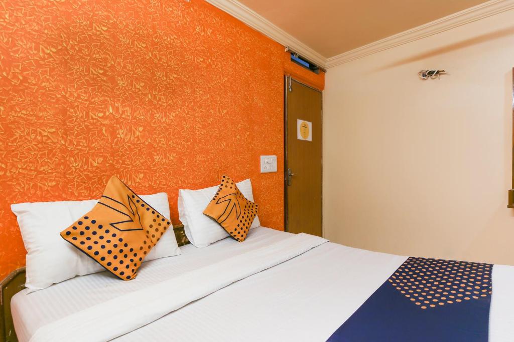 a bedroom with a bed with pillows on it at SPOT ON Hotel Super Guest House in Ahmedabad