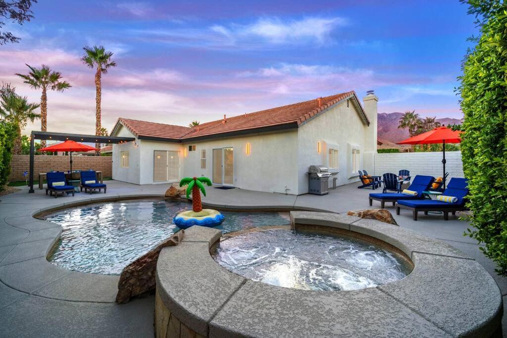 un patio trasero con piscina y una casa en NEW! The Blue Cactus - Pool, Spa, Game Room, en Palm Springs