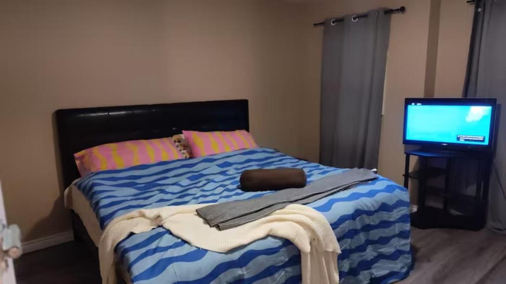 a bedroom with a bed with a television on it at Waterloo Master bedroom with attached bathroom in Waterloo