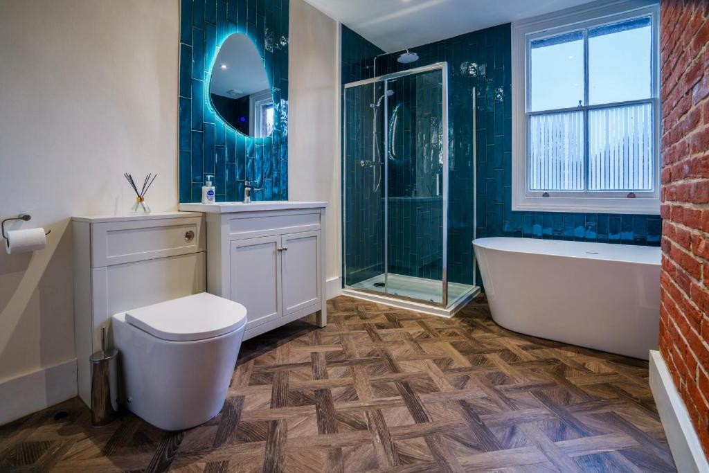 a bathroom with a tub and a toilet and a shower at The Castle City Centre Apartment in Canterbury