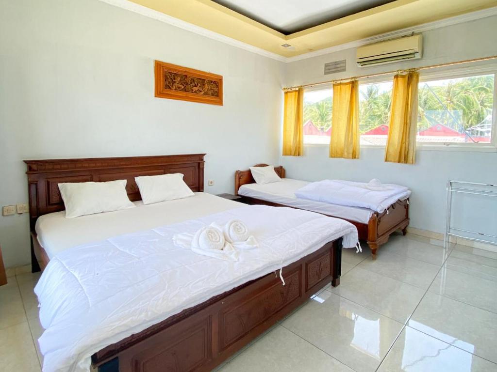 1 dormitorio con 2 camas y ventana en Puri Karimunjawa RedPartner en Karimunjawa