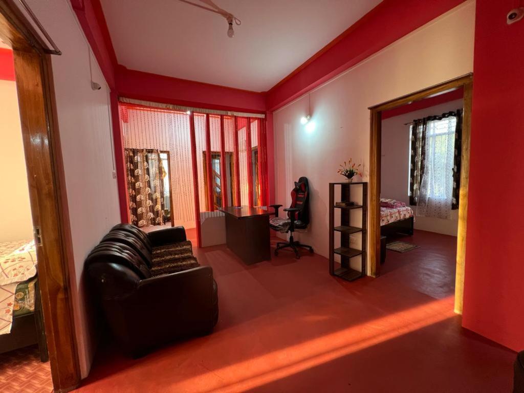 ein Wohnzimmer mit einem Ledersofa und einem Schreibtisch in der Unterkunft 1010 NK Homestay in Shillong