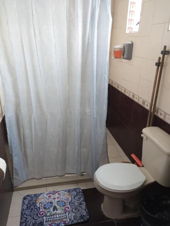 y baño con aseo y cortina de ducha. en Departamento céntrico y cerca del foro sol, en Ciudad de México