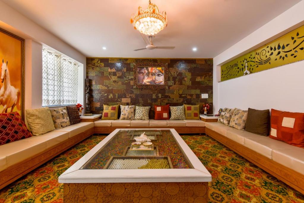 a living room with a large couch and a chandelier at OYO Flagship Hotel Sawraj Regency in Sohāna