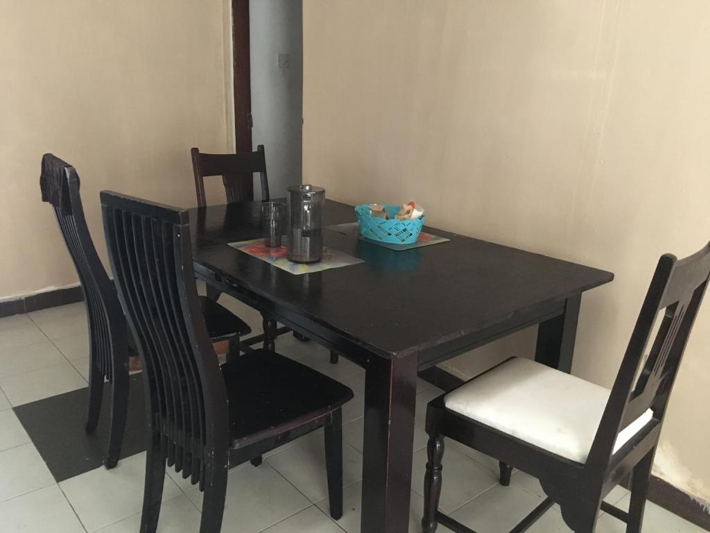 蒙巴薩的住宿－Tropical paradise，一张带椅子的木桌和一个碗
