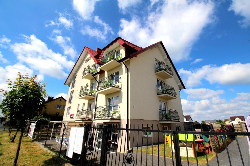 a white building with a fence in front of it at Willa Magnolia in Władysławowo