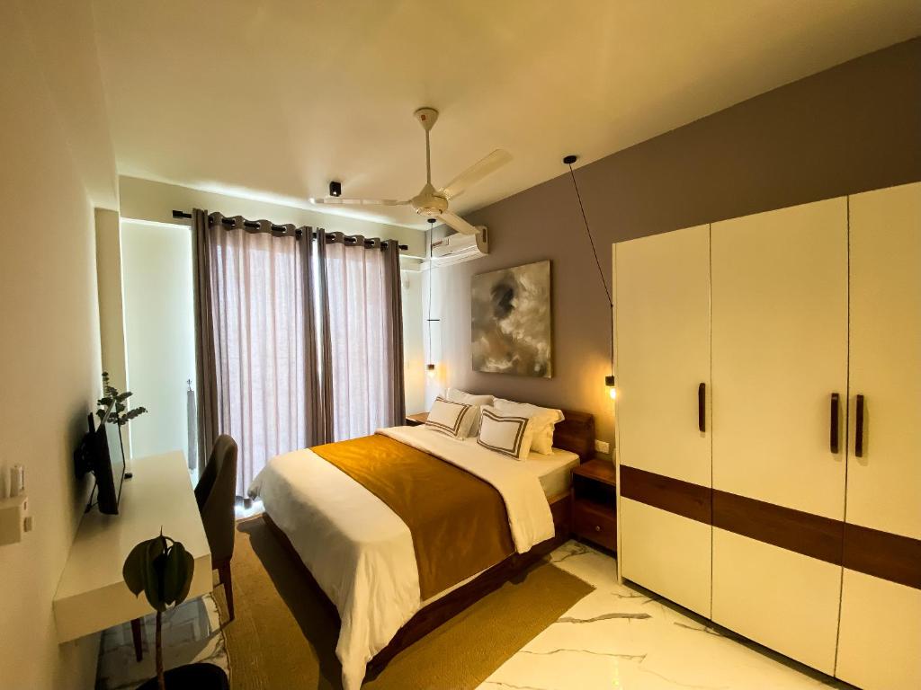 1 dormitorio con cama y ventana grande en Marine Breeze Residencies en Colombo