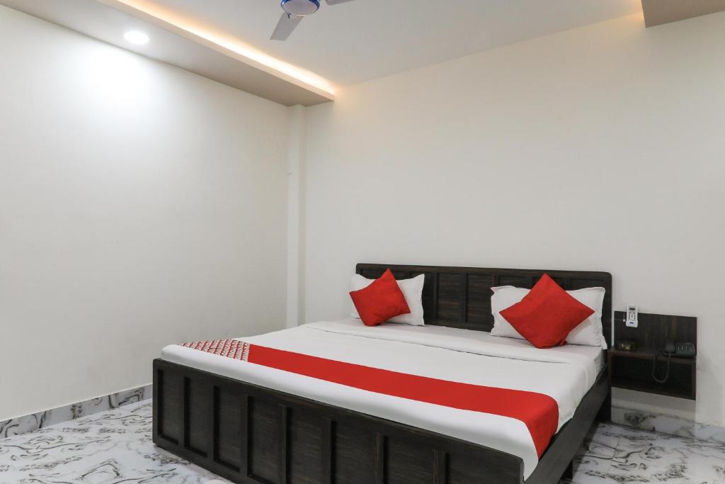 Un dormitorio con una cama con almohadas rojas. en OYO Hotel Aastha Near Chaudhary Charan Singh International Airport, en Bijnaur
