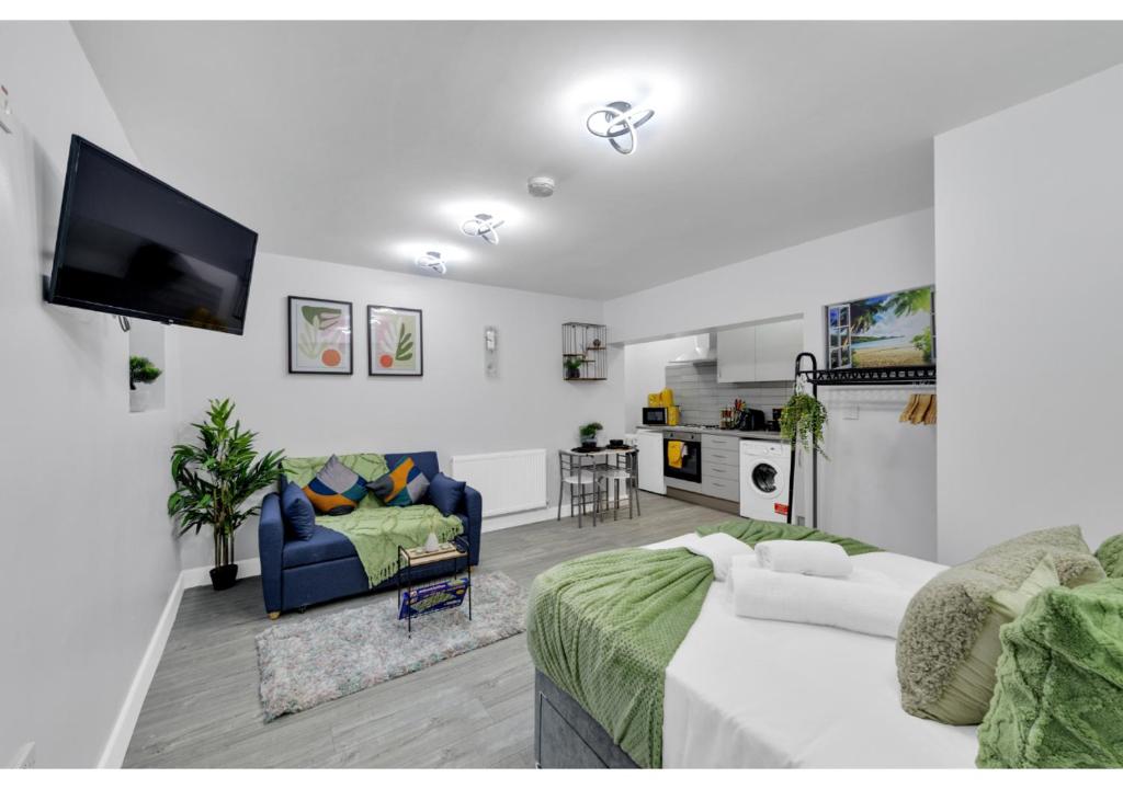 ein Wohnzimmer mit einem Bett, einem Sofa und einem TV in der Unterkunft Green Haven Sleeps Two in London