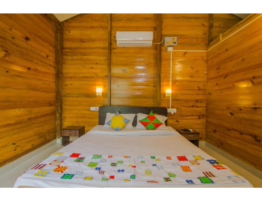 - une chambre avec un lit et des murs en bois dans l'établissement Mermaid Resort, Arambol, Goa, à Arambol