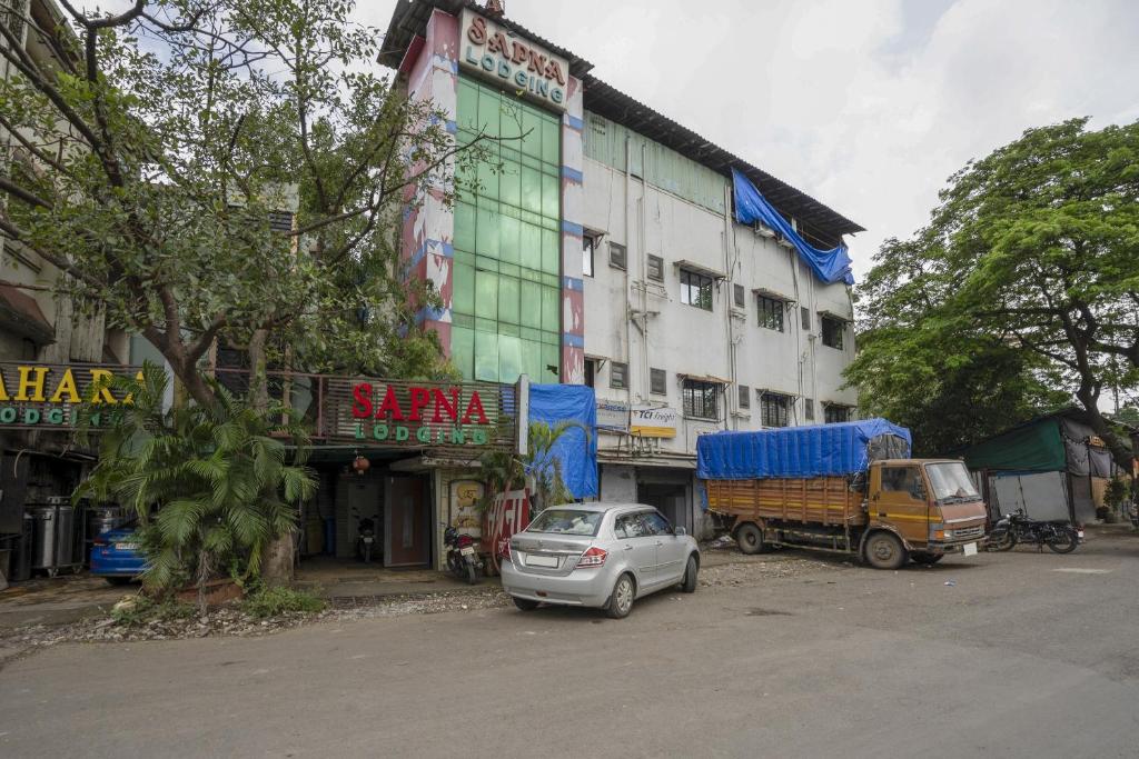 a car and a truck parked in front of a building at Hotel Sapna Near Anand Nagar (Dahisar) Metro Station in Mire