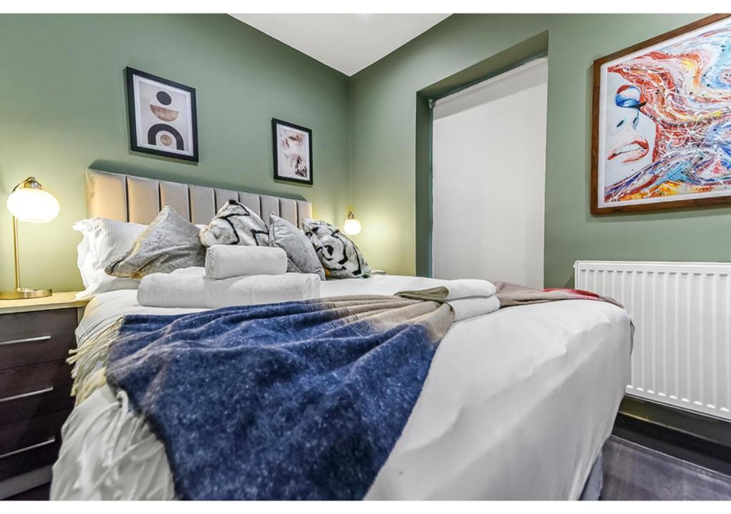 Un dormitorio con una cama grande con una manta azul. en Gorgeous Home VERY Close to the Fast Tube! en Londres