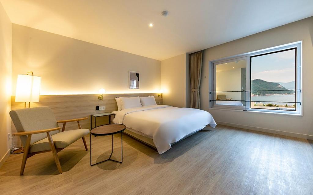 a hotel room with a bed and a large window at Hotel Yaja Masan Odong Branch in Masan