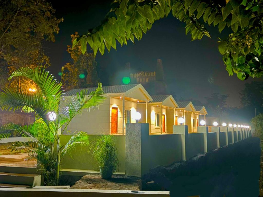 eine Reihe von nachts erleuchteten Häusern in der Unterkunft Tara's Hill Resort in Lonavla